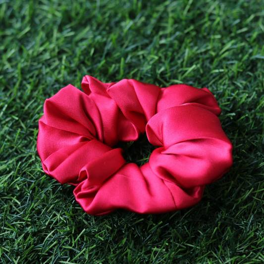 Red scrunchie on green grass