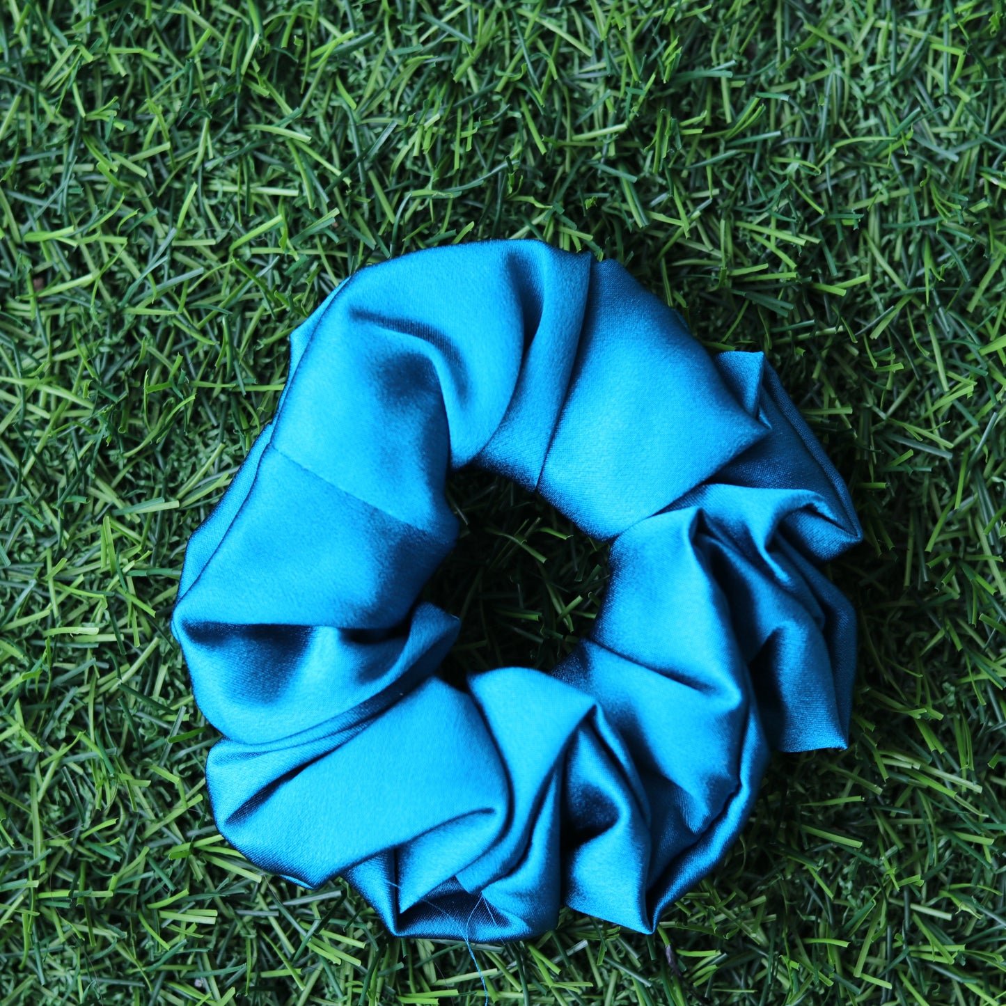 Blue scrunchie on green grass