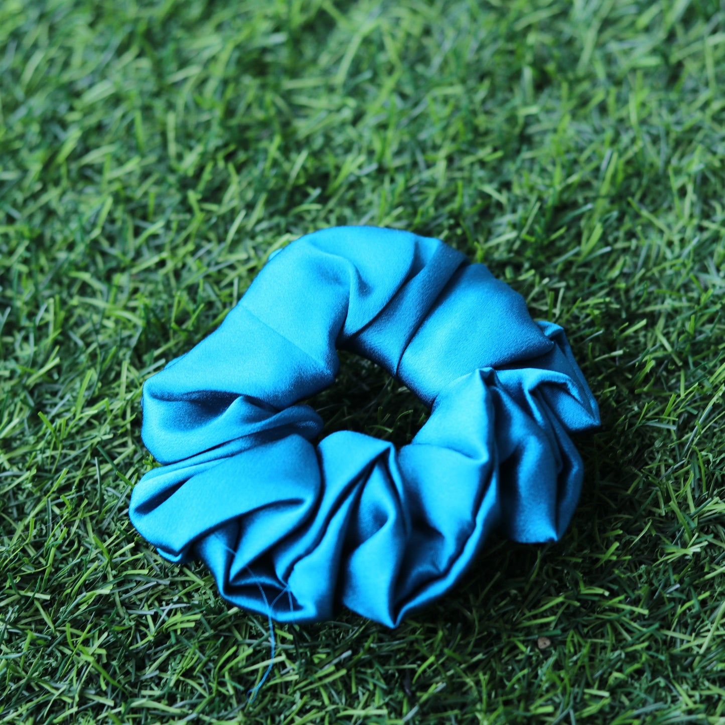 Blue scrunchie on grass