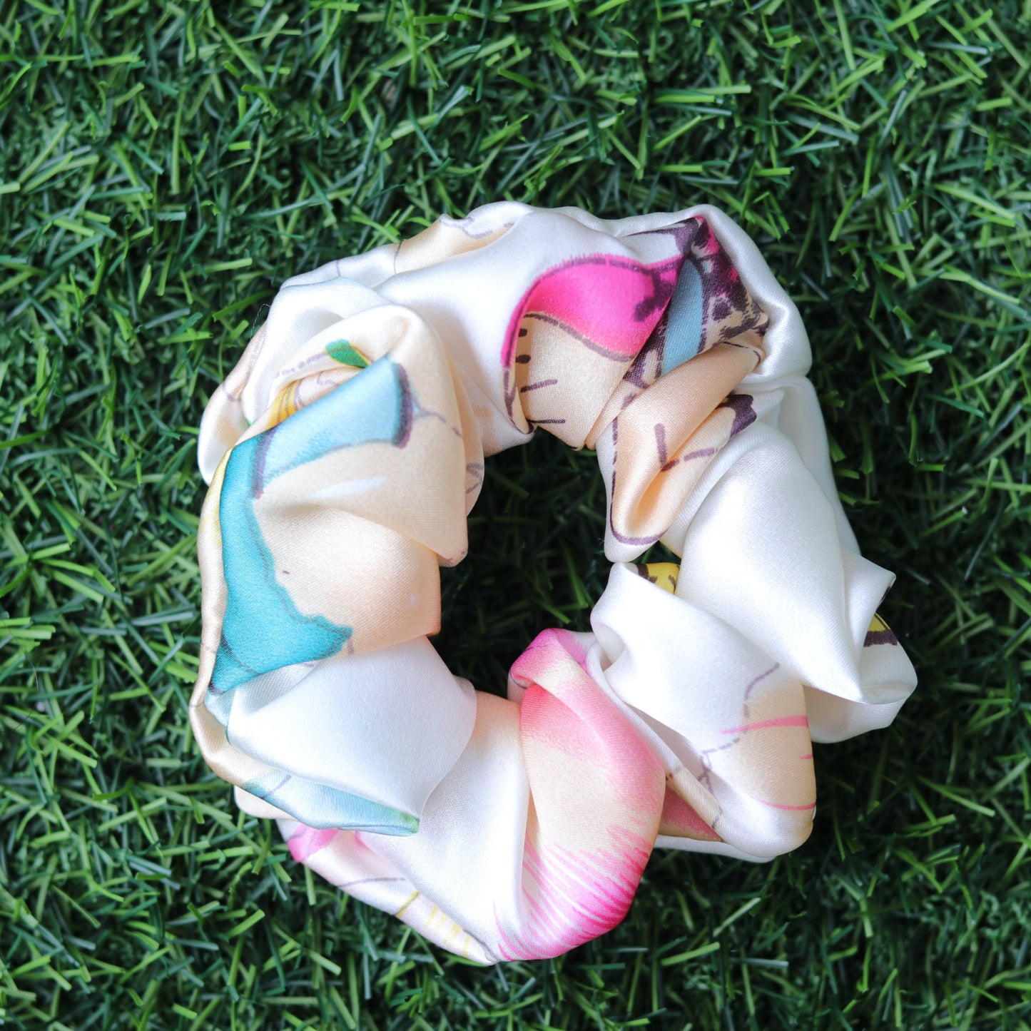Decorative scrunchie with floral patterns on a grass background